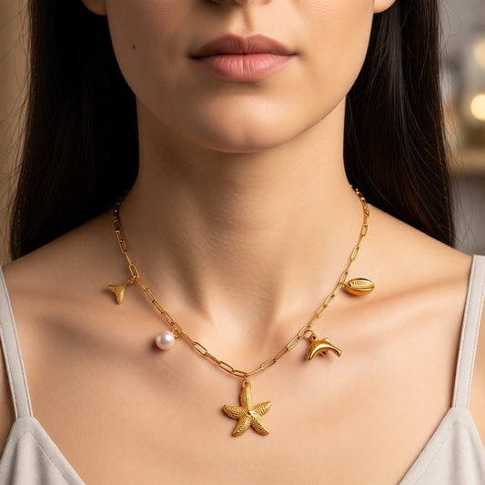 Aramat Jewels gold-tone stainless steel necklace with sea charms: starfish, dolphin, shell, shark fin, and pearl. 45 cm.