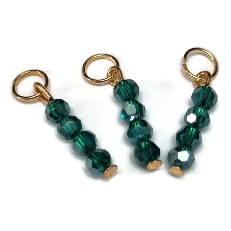 Een paar groene glaskralen met gouden accenten