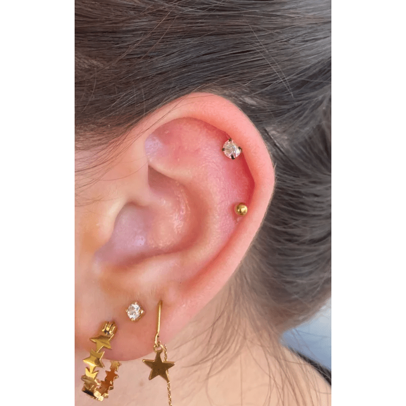 Een vrouw met een gouden ster oorpiercing