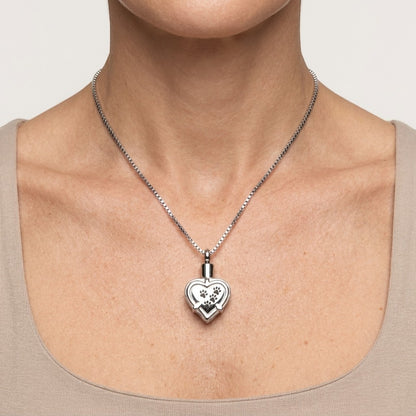 Aramat Jewels zilverkleurige hartvormige ashanger met pootafdrukken, gemaakt van roestvrij staal.