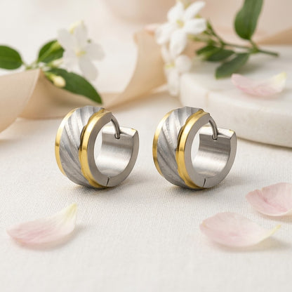Aramat Jewels huggie hoop earrings in bicolor gold and silver stainless steel with a textured, diamond-cut design.