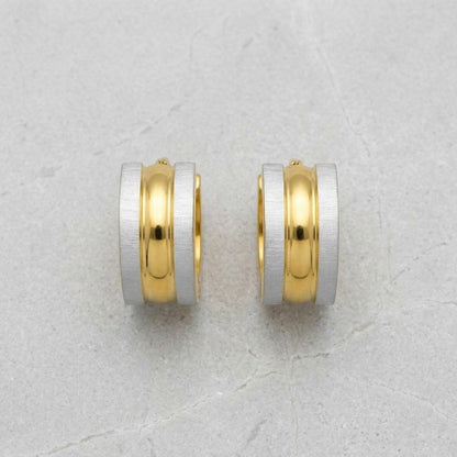 Aramat Jewels bicolor RVS huggie hoop earrings with a matte silver exterior and a polished gold interior.