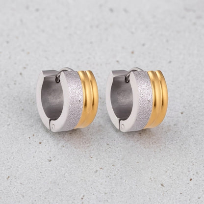 Aramat Jewels bicolor huggie hoop earrings in stainless steel with matte silver and shiny gold stripes, 13mm diameter.