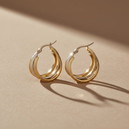 Aramat Jewels bicolor triple hoop earrings with a diamond-cut pattern in gold and silver stainless steel, 35mm diameter.