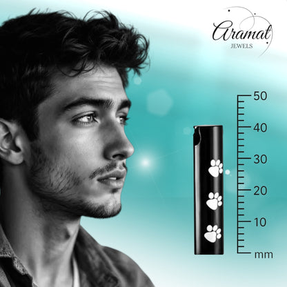 Aramat Jewels black stainless steel cremation urn pendant with white paw prints. Cylindrical shape, 3.4cm.