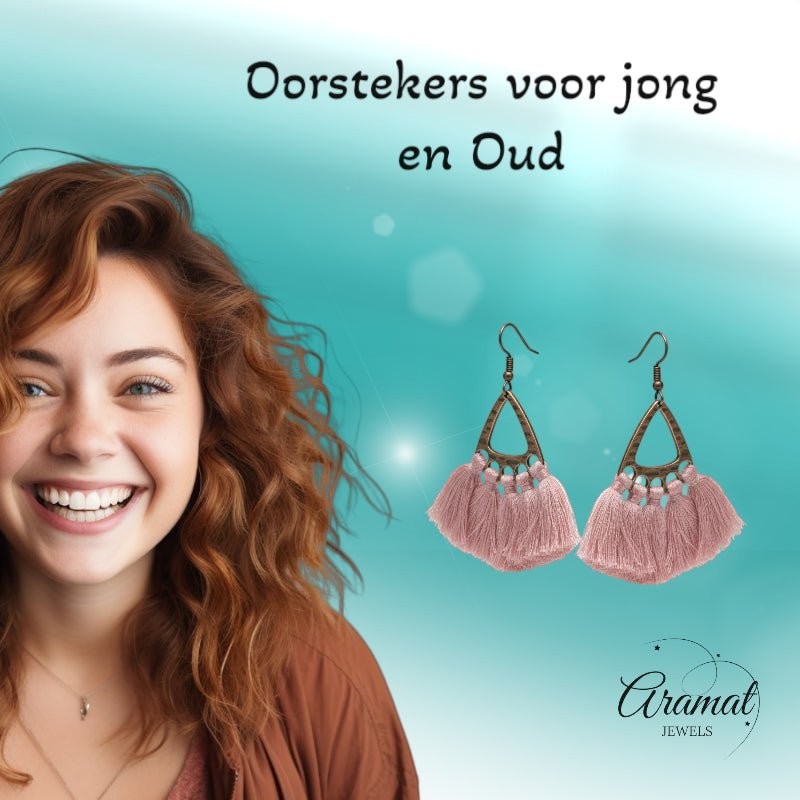 Lachend model met Aramat Jewels boho oorhangers met licht roze kwastjes en bronskleurige metalen details.