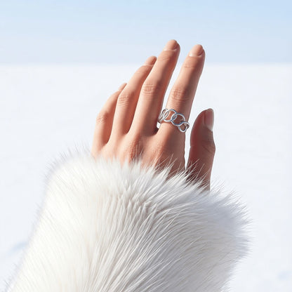 Aramat Jewels brede zilverkleurige RVS ring met ovale schakels gedragen aan een hand met witte bontmanchet.