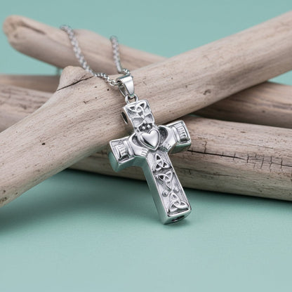 Aramat Jewels silver-tone Celtic cross cremation pendant with intricate knotwork and a heart detail. The pendant is on a silver chain.