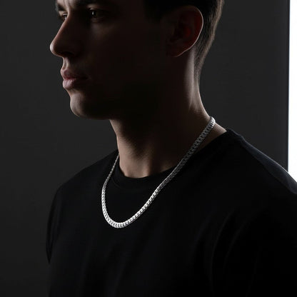 Aramat Jewels chunky 8mm zilverkleurige gourmet ketting van RVS gedragen door een man in een zwart shirt.