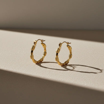 Aramat Jewels gold-coloured stainless steel hoop earrings with a block pattern and hinge closure, 25x23mm.