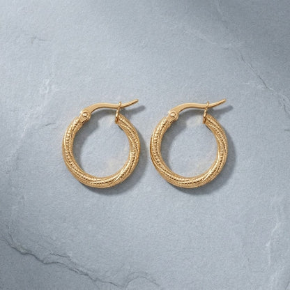 Aramat Jewels gold-tone twisted, diamond-cut stainless steel hoop earrings, 20mm diameter, with hinge clasp.