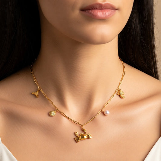 Aramat Jewels gold-tone stainless steel necklace with sea-themed charms: crab, shell, fish tail, starfish, and pearl. 45 cm.