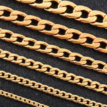 Aramat Jewels goudkleurige gourmet kettingen van roestvrij staal in verschillende breedtes op een zwarte achtergrond.