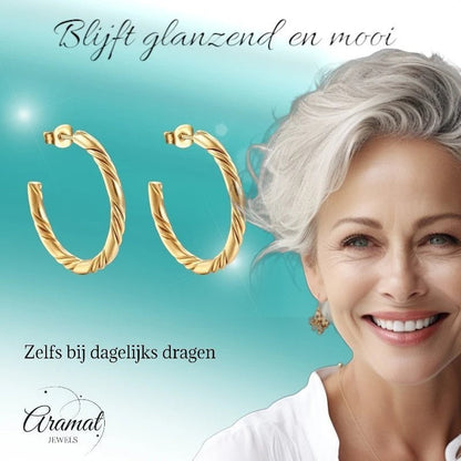 Aramat Jewels goudkleurige halve oorringen van RVS met gedraaid motief, 30mm diameter, gedragen door een vrouw.