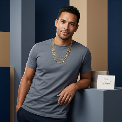 Man draagt een goudkleurige Aramat Jewels koffieboon ketting van 5,2mm breed en 60cm lang in een stijlvolle setting.