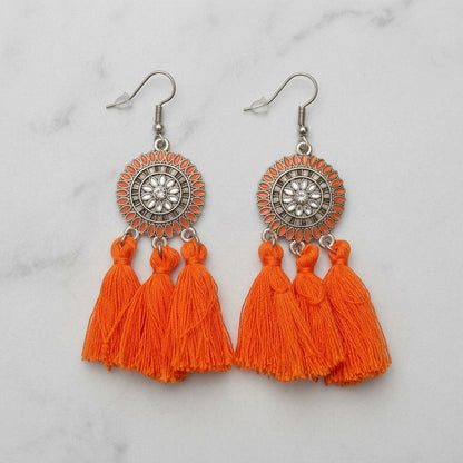Aramat Jewels oranje boho oorhangers met kwastjes en zilverkleurige details. 75mm lang.