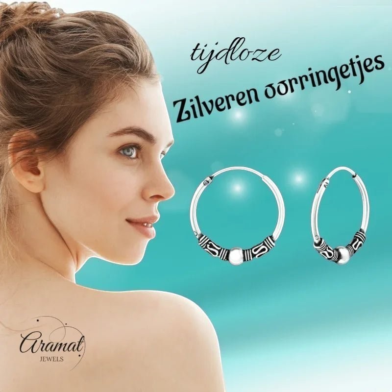 Aramat Jewels 18mm oxidized silver Bali hoop earrings with ethnic patterns and a central bead.