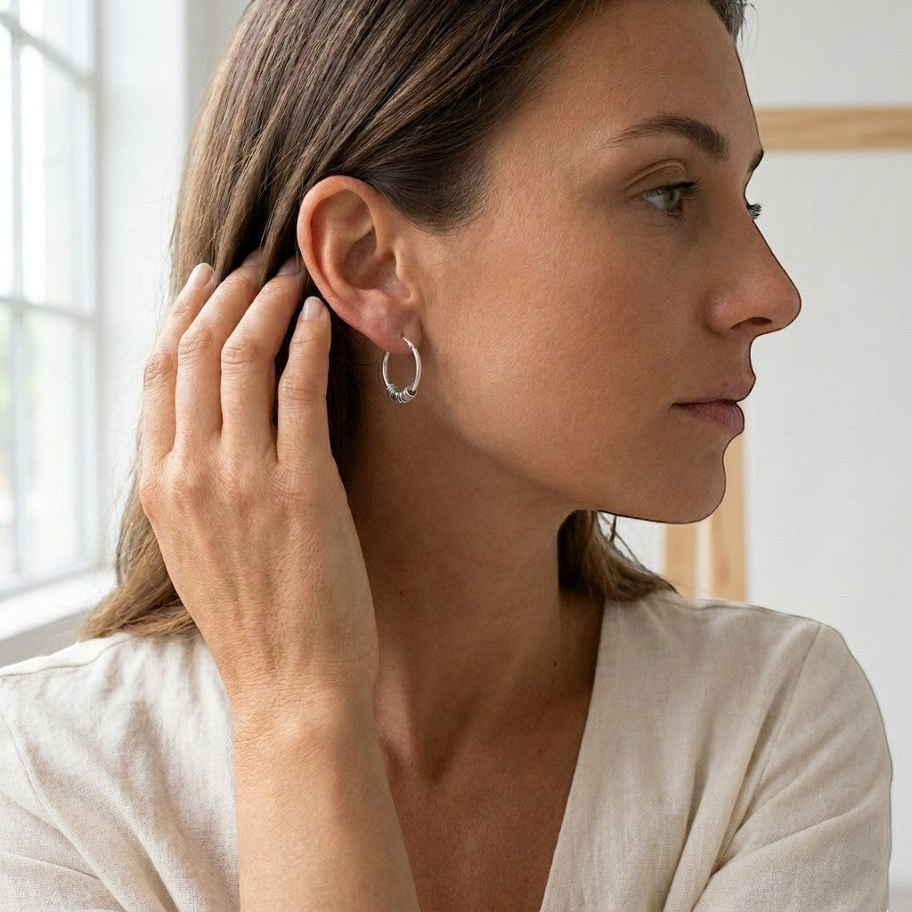 Aramat Jewels 18mm oxidized silver Bali hoop earrings with intricate detailing, worn by a woman.