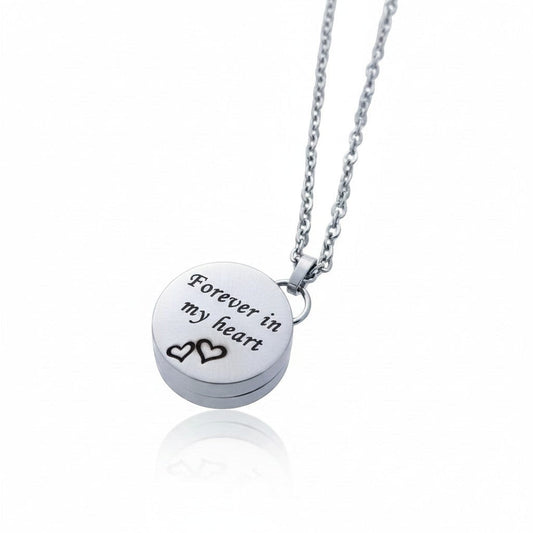 Aramat Jewels zilverkleurige RVS ashanger in hartvorm met de tekst 'Forever in my heart' en twee hartjes. Inclusief 50cm ketting.