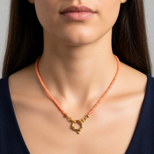 Aramat Jewels gold-tone necklace with salmon pink seed beads and a circular clasp.