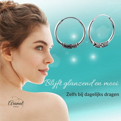 Aramat Jewels unisex 16mm silver Bali hoop earrings with ethnic detailing, worn by a woman.
