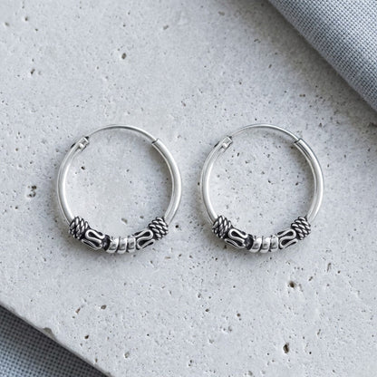 Aramat Jewels unisex silver Bali hoop earrings, 16mm diameter, with intricate braided and cylindrical bead details.