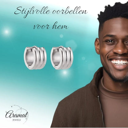 Aramat Jewels silver-colored stainless steel hoop earrings with ribbed detail, worn by a smiling man.