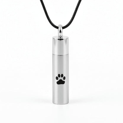 Aramat Jewels matte silver stainless steel cylinder cremation urn pendant with black paw print detail, 46mm.
