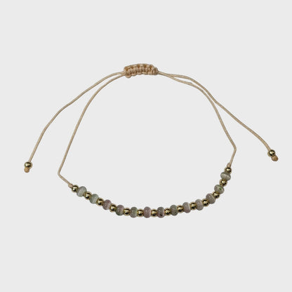 Aramat Jewels verstelbaar enkelbandje met glanzende cats eye kralen en goudkleurige accenten op beige touw.