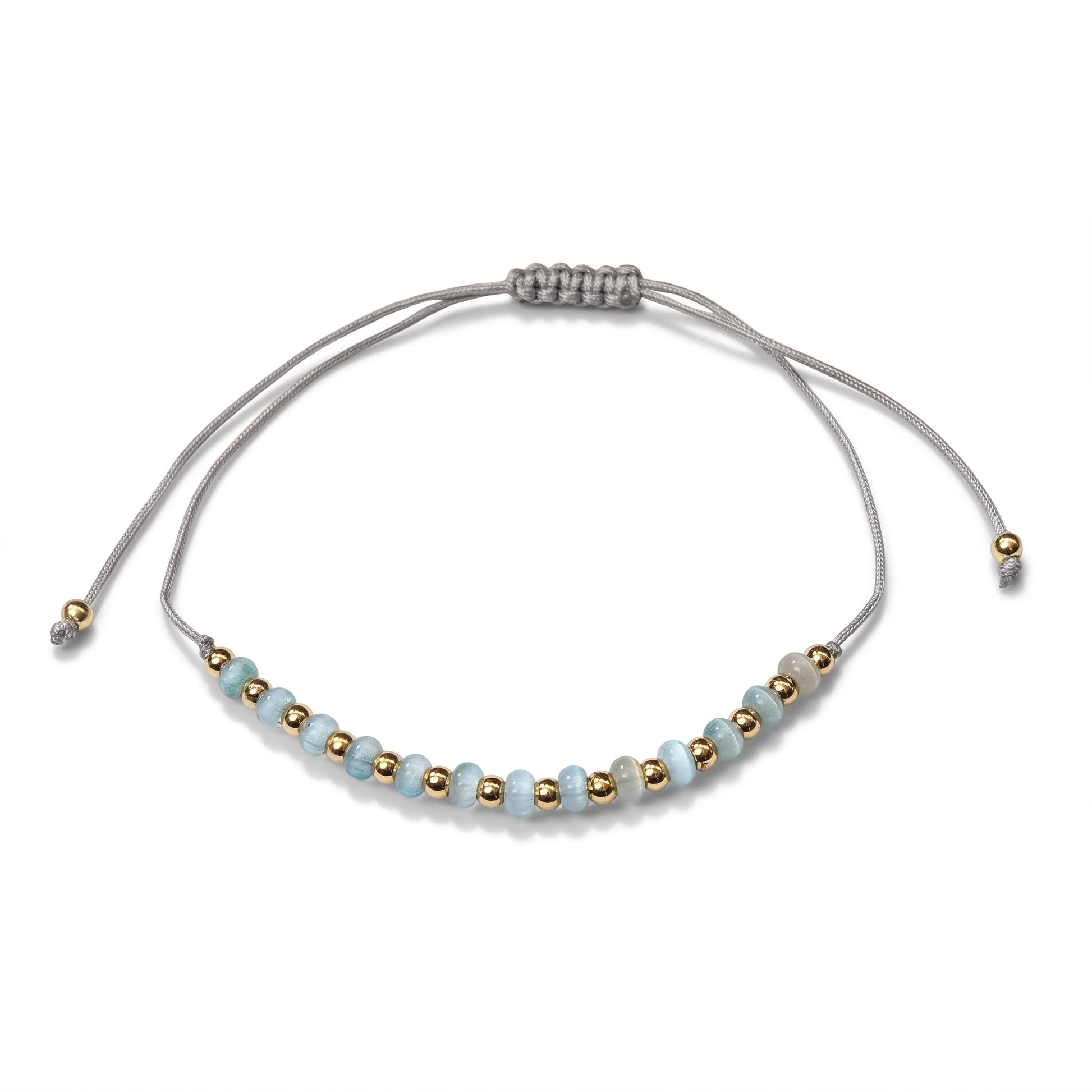 Aramat Jewels verstelbaar enkelbandje met lichtblauwe cats eye kralen en goudkleurige accenten op een grijs touwtje.