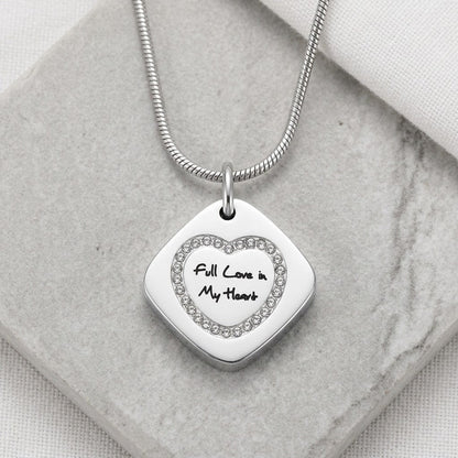Aramat Jewels vierkante stalen ashanger met hartvormige zirkonia's en tekst 'full love in my heart'.