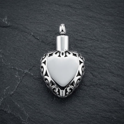 Aramat Jewels zilverkleurige hartvormige ashanger met sierlijke rand, gemaakt van roestvrij staal.