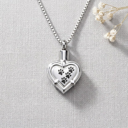 Aramat Jewels zilverkleurige hartvormige ashanger met pootafdrukken, gemaakt van roestvrij staal.