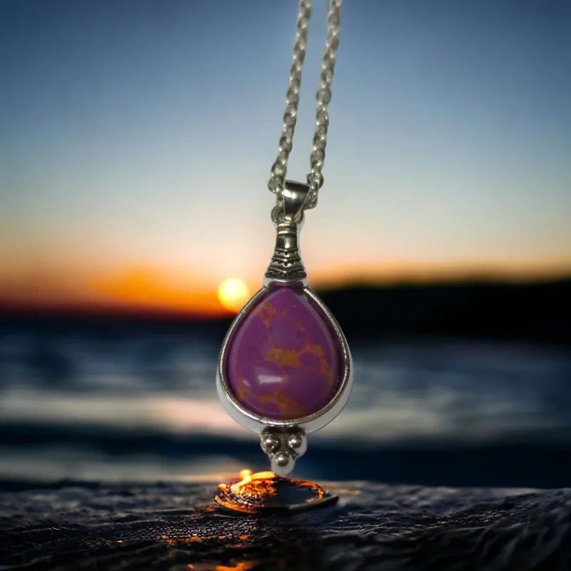 Een paarse stenen hanger hangt aan een zilveren ketting