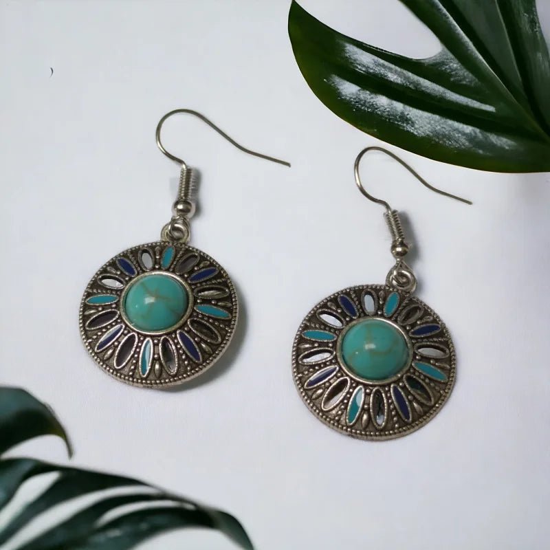 Een paar oorbellen met turquoise en zilveren accenten
