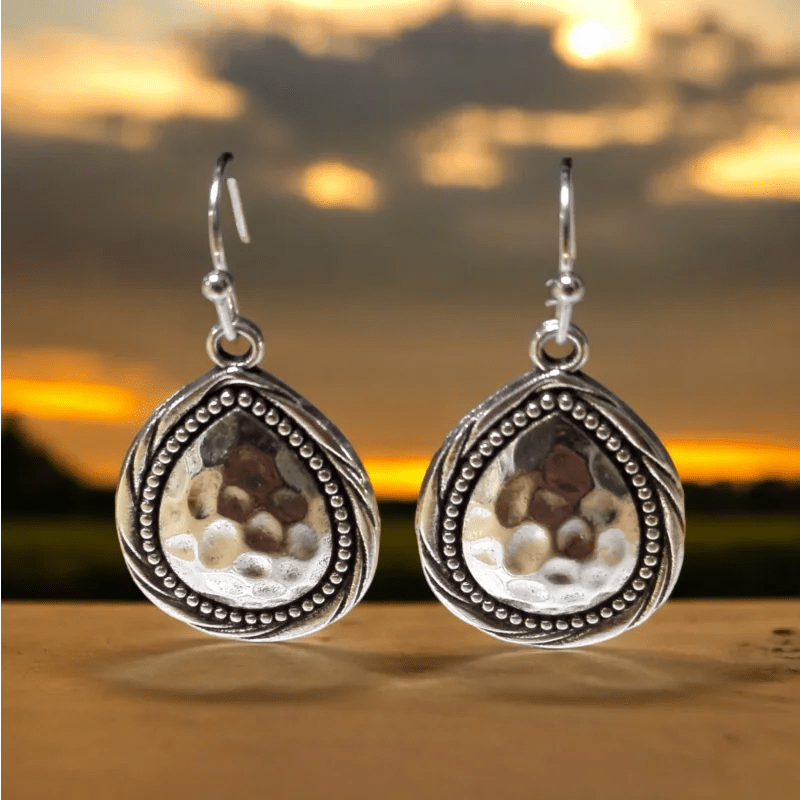 Paar sierlijke zilveren traanvormige oorbellen met kralenontwerpen en ingezette stenen.