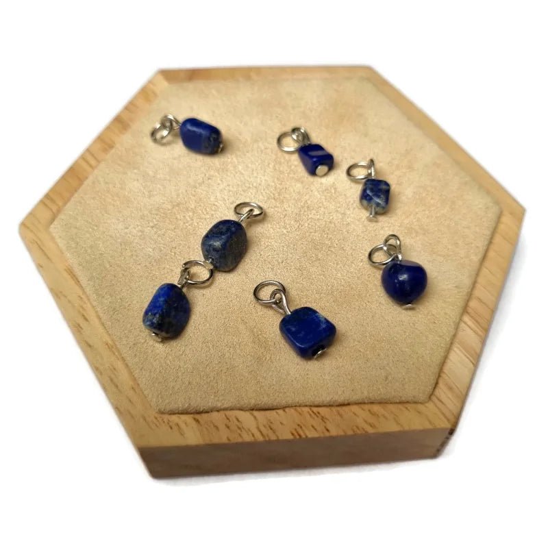 Er zijn vijf blauwe kralen op een houten dienblad met een houten basis