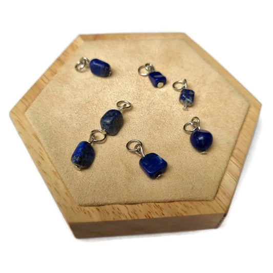 Er zijn vijf blauwe kralen op een houten dienblad met een houten basis