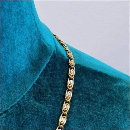Een close-up van een gouden ketting op een blauw shirt