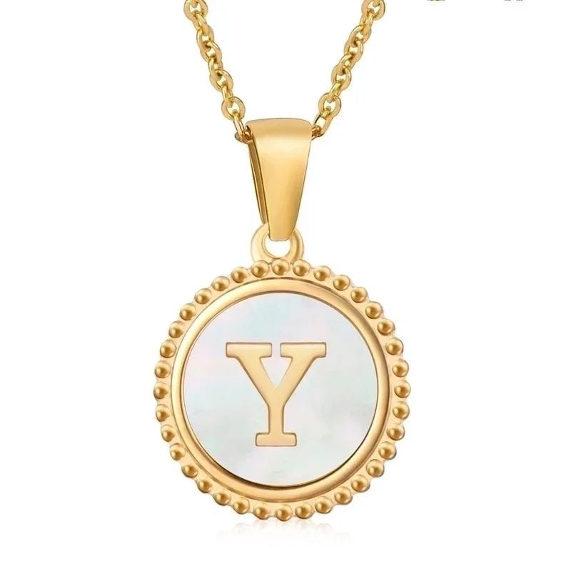 Vergulde hanger ketting met de letter ’Y’ op een parelachtige ronde schijf met kralenrand.