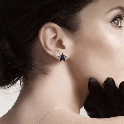 Een vrouw met een paar zwarte handschoenen en een ster oorbel