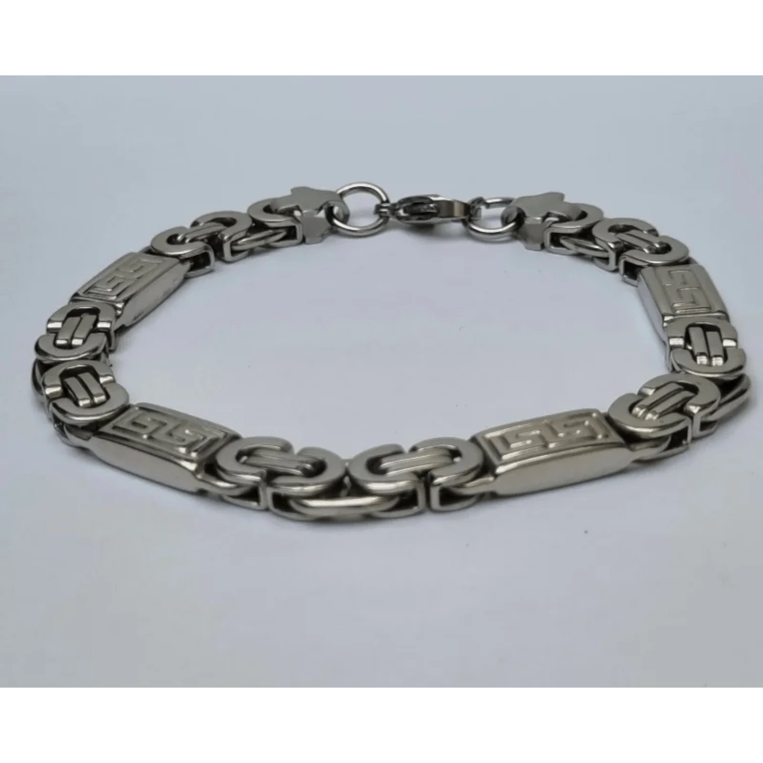 Een zilveren armband met een schakel en een sluiting