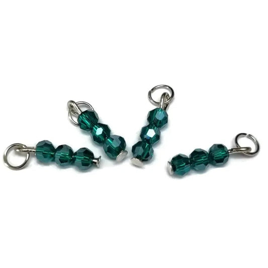 Drie groene glazen kralen op een wit oppervlak