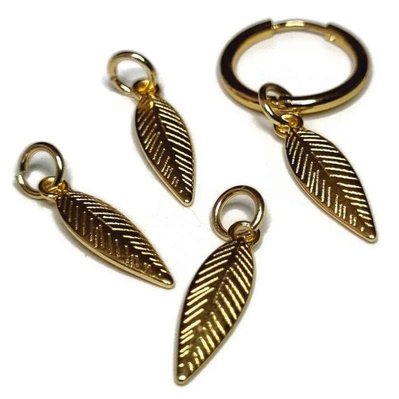 Een paar goudkleurige metalen bedels met veren