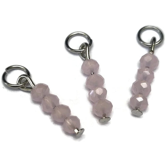 Een paar roze kwartskralen met zilveren slotjes