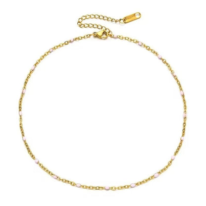 Een gouden armband met roze kralen en een gouden ketting