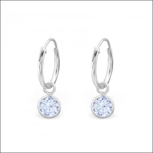 Een paar zilveren oorbellen met een witte topaas