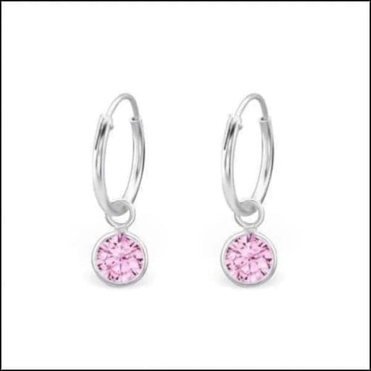 Een paar roze kristallen oorbellen met zilveren hoepels