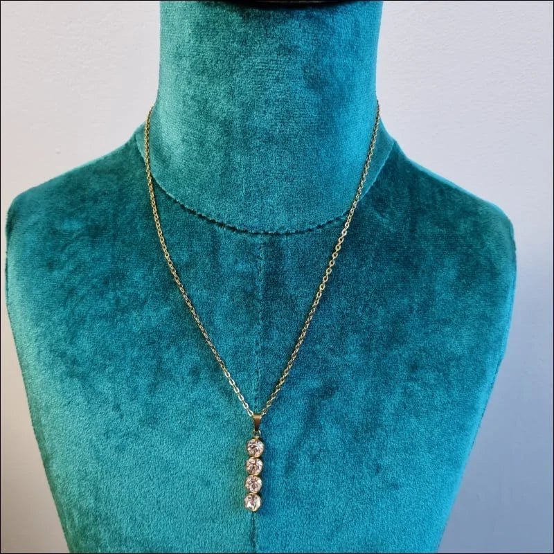 Een halsketting met een gouden ketting en een witte diamant