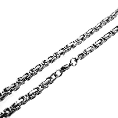 Een zwarte ketting met een zilveren schakel